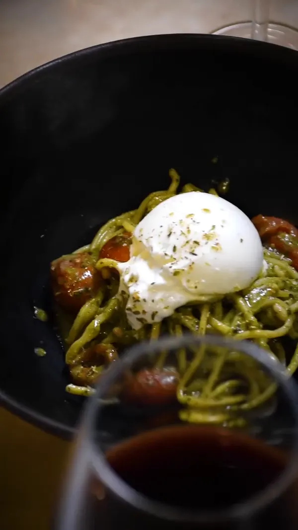 Primer plano de la burrata, con una copa delante.